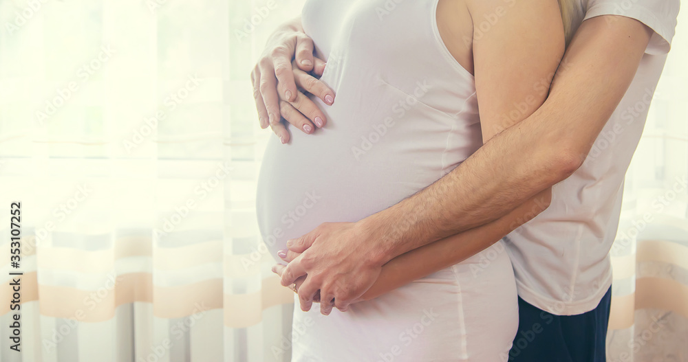 A pregnant woman and a father of a child hug a belly. Selective focus. - obrazy, fototapety, plakaty 