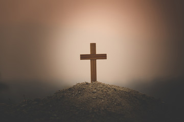 A cross placed on a hill to pray to God. As the sun is setting higher religious concepts, the crucifixion of faith, faith in God, prayer, struggle and God's victory.