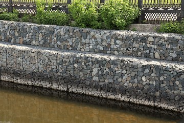 
The shore of the lake reinforced by a gabion of large natural stone