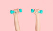 © Prostock-studio - Young girl lifting dumbbells on pink background, closeup of hands. Panorama