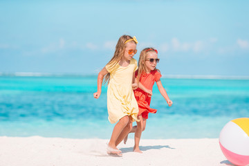 Little adorable girls playing with air ball on the beach. Kids having fun on the seashore