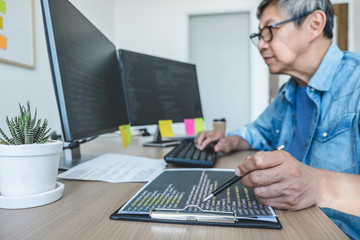 Senior Professional programmer working at developing programming and website working in a software develop company office, writing codes and typing data code