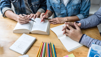 Wall Mural - high school or college student group sitting at desk in library studying and reading, doing homework