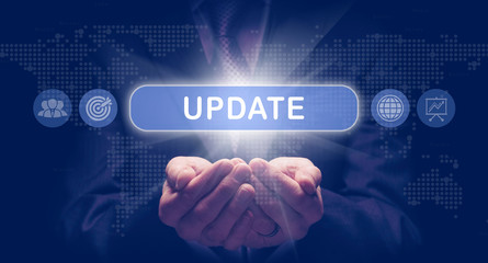 Businessmans cupped hands holding an Update business concept on a computerised display.