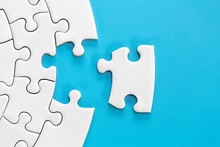 White Jigsaw Puzzle Pieces On A Blue Background. Problem Solving Concepts. Texture Photo With Copy Space For Text