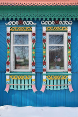 Richly decorated ornamental carved windows, frames on vintage wooden rural house in Ivanovo city, Russia. Russian traditional national folk style in wooden architecture. Landmark. Soviet symbolics