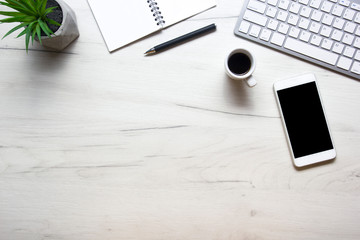 White desk office with laptop, smartphone and other work supplies with cup of coffee. Top view with copy space for input the text. Designer workspace on desk table essential elements on flat lay