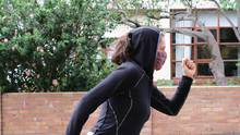Side Profile Of Female Training During Corona Virus Epidemic. She Is Facing The Viewer And Is Wearing A Pink And Black Face Mask Which Is Compulsory To Wear In Public.