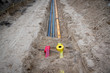 Rohre und Flatterband, Absperrband für Gasleitung und Lichtwellenleiter, Glasfaser in Baustelle in einem Baugebiet