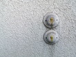 Alte runde Lichtschalter im Stil der Fünfzigerjahre auf ergrautem Rauputz eines Wohnhaus in Wettenberg Krofdorf-Gleiberg bei Gießen in Hessen