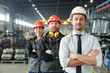 © pressmaster - Confident leaders of manufacturing production plant standing with crossed arms in row at factory