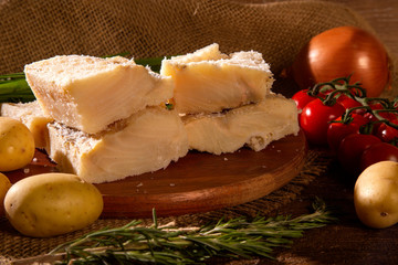 salted codfish on the wooden table with ingredients. Codfish raw.