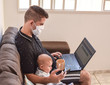 © asaffsouza - Father and son working on laptop, Masked father with notebook and his baby beside