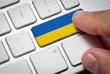 Fototapeta  - Online International Business concept: Computer key with the Ukraine flag on it. Male hand pressing computer key with Ukraina flag.