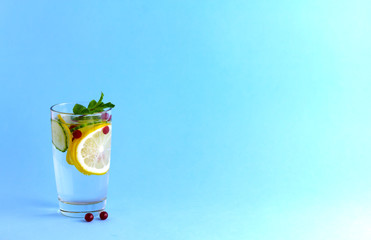 Sassy diet water. Cucumber, lemon, mint lemonade in a glass on a blue background