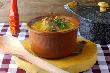 canjiquinha a traditional dish of Brazilian cuisine made with pork ribs and crushed corn, in a ceramic bowl on a rustic wooden table. Close up view