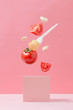 Pasta ingridients in free fall. Spaghetti, tomato and garlic against pastel pink background. Minimal food concept.