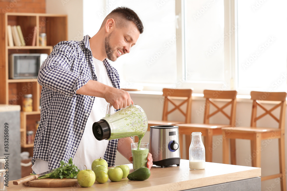 Man with healthy homemade smoothie in kitchen