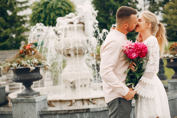 Wall Mural - Cute couple in a park. Lady in a white dress. Guy in a white shirt.