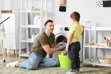 Sticker - Man and his little son doing laundry at home