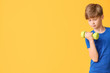 © Pixel-Shot - Sporty little boy with dumbbells on color background