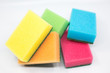 © Wiktoria - colorful sponges for washing dishes scattered around on a white background