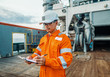 © Igor Kardasov - Filipino deck Officer on deck of offshore vessel or ship , wearing PPE personal protective equipment. He fills checklist. Paperwork at sea