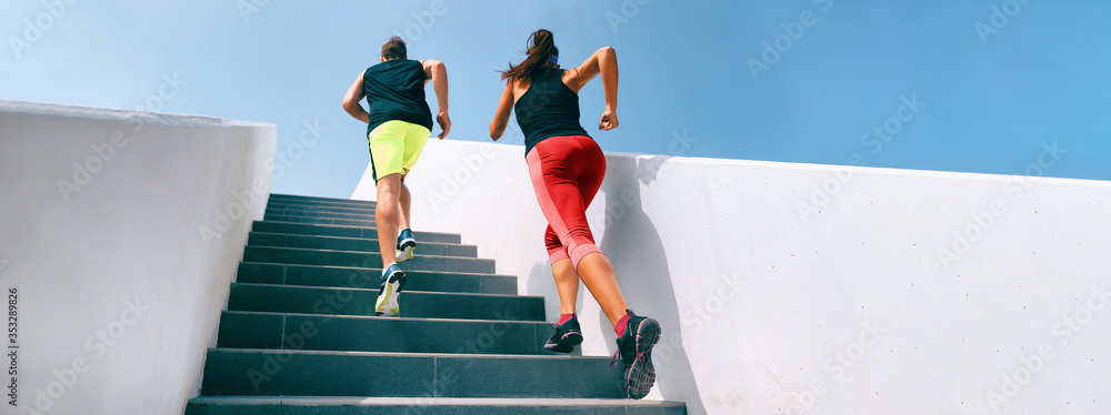 Stairs running up couple athletes runners running up staircase exercising cardio with hiit interval training workout. Fitness gym active sport people climbing in urban city panoramic banner. - obrazy, fototapety, plakaty 