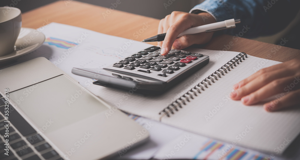 The accountant's hand is using the calculator. For cost analysis Profit ...