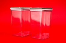 Transparent Plastic Containers For Storing Bulk Products, Cereals And Pasta, Photographed Large On A Red Background.