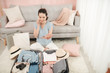 © makistock - Tourist talking on phone, booking hotel and holding passport, ticket, preparing for vacation