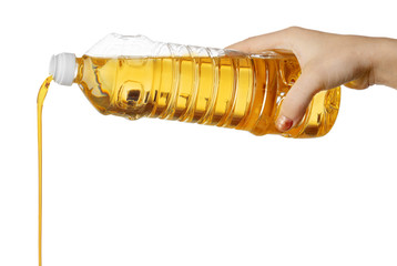 Hand of woman pouring cooking oil from plastic bottle. Isolated on white background.