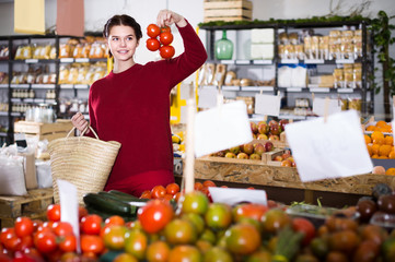 Young girl  buying   tomatoes  at market