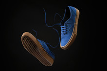 Close Up View Of Levitation Blue Sneakers Shoes With  Flying Laces Over Black Background With Copy Space For Text. 
