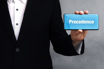 Precedence. Businessman holding a phone in his hand. Man present screen with word. Blue Background. Business, Finance, Statistics, Analysis, Economy