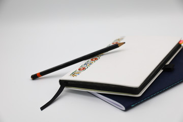 Two notebooks and a pencil with a white background