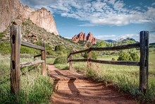 Wood Fence Frames A Hiking Trail Which Leads Towards Interesting Rock Formations In Garden Of The Gods Park In Colorado Springs.
