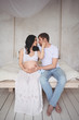 © Алина Троева - Pregnancy and people concept - happy man hugging his beautiful pregnant wife at home. Future parents waiting unborn baby. Love, relationship, birth, happy family concept - young lovely married couple