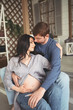 © Алина Троева - Pregnancy and people concept - happy man hugging his beautiful pregnant wife at home. Future parents waiting unborn baby. Love, relationship, birth, happy family concept - young lovely married couple