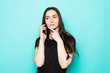 © dianagrytsku - Attractive girl talking on the phone isolated over blue turquoise background
