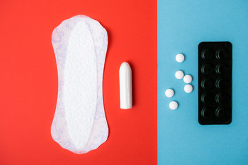 Menstruation concept. Personal hygiene items for women. Photo of painkillers, tampons and panty liners top view.