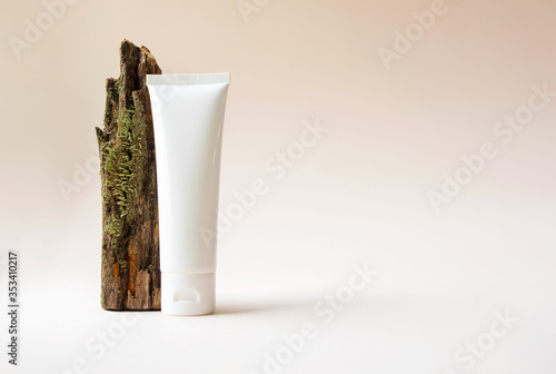 Mockup white plastic tube with moisturizer cream, facial cleanser or shampoo and tree branch with moss on beige background with copy space Tableau sur Toile