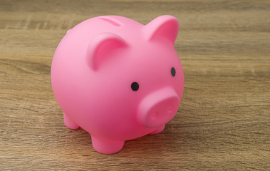 Pink piggy bank on the wood floor