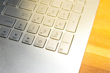 Close up detail view of laptop computer metalic keyboard on wooden table for Business idea concept background