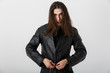 © Drobot Dean - Portrait of brunette young man with long hair wearing black lather jacket posing and looking at camera