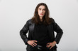 © Drobot Dean - Portrait of brunette caucasian man with long hair wearing black lather jacket posing and looking at camera