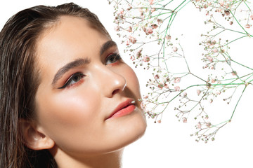 Blooming. Close up of beautiful young woman with tender flowers on white background. Concept of cosmetics, makeup, natural and eco treatment, skin care. Shiny and healthy skin, fashion, healthcare.