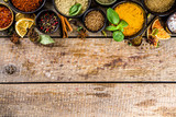 Fototapeta Kuchnia - Set of Spices and herbs for cooking. Small bowls with colorful  seasonings and spices - basil, pepper, saffron, salt, paprika, turmeric. On rustic wooden plank table background, top view copy space