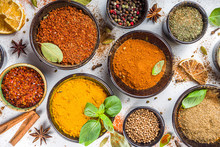 Set of Spices and herbs for cooking. Small bowls with colorful  seasonings and spices - basil, pepper, saffron, salt, paprika, turmeric. On white stone table background top view copy space