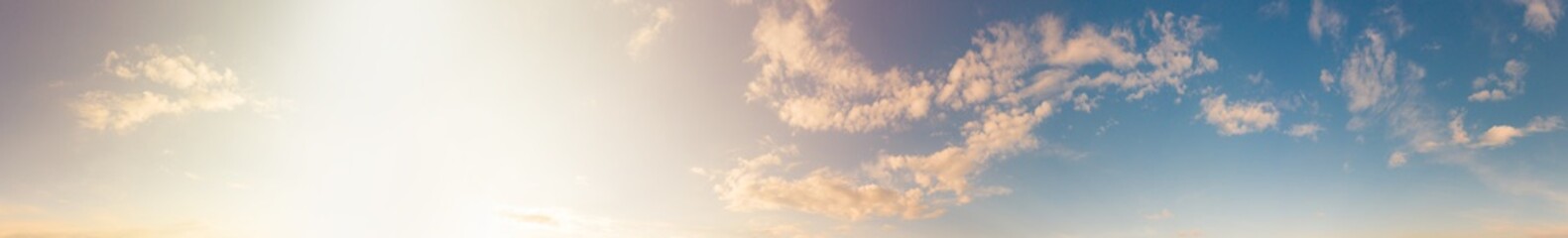 warm sunny blue sky with fluffy clouds. sunset sunlight illuminates the sky in sunset time. beautifu